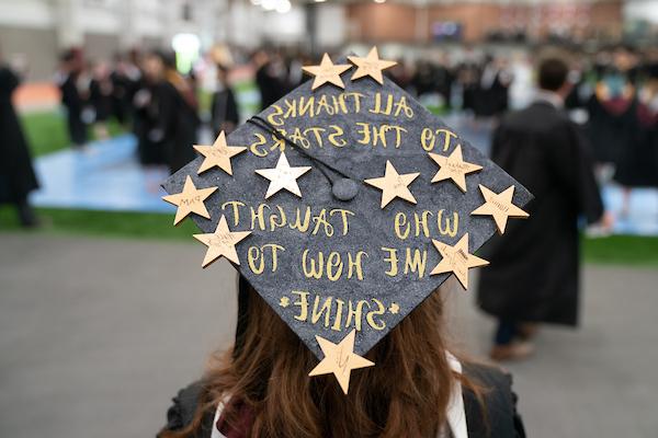 Graduation cap decorated with gold stars reading "To all the stars that taught me how to shine"